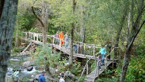 Tourists crossed the river on the bridge Stock Footage 77705703