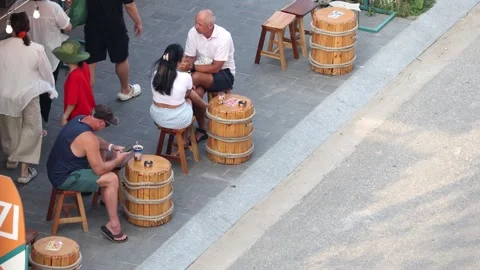 Tourists with drinks sit at small tables on the sidewalk Stock Footage 310178387