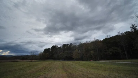 Tourists Drive By with Beautiful Clouds Tracking Overhead in Cades Cove Stock Footage 119880103