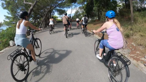 Tourists eBiking along a cycling path in up a steep winding road in Europe Stock Footage 323334811