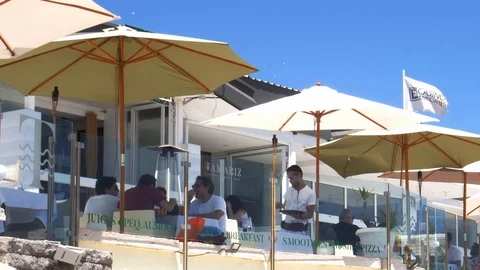 Tourists enjoy drinks and conversation on a terrace in Estoril, Portugal Stock Footage 112880330