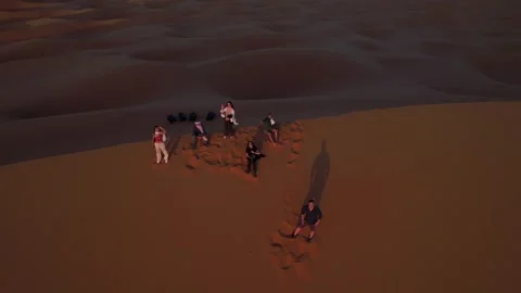 Tourists on Erg Chebbi dune crest at sunrise in Sahara Desert, Morocco, aerial Stock Footage 339044454