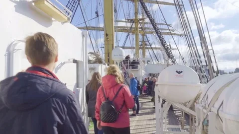 Tourists on excursions walk along the deck of the ship sailboat Kruzenstern. Stock Footage