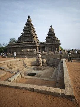 Tourists explore the ancient rock cut Shore Temple a historic UNESCO World .. Stock Photos