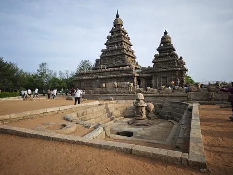 Tourists explore the ancient rock cut Shore Temple a historic UNESCO World .. Stock Photos