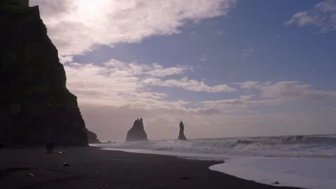 Tourists explore basalt columns and ocean waves at Reynisfjara Beach in Iceland 스톡 동영상 329443047
