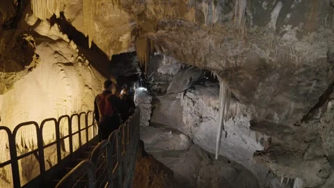Tourists explore a cave with a beautiful background Stock Footage 243848109