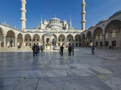Tourists Explore the Inner Courtyard of the Blue Mosque in Istanbul Foto stock