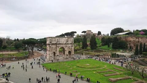 Tourists exploring the ancient Arch of Constantine and Palatine Hill in Rome Stock Photos