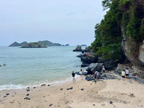Tourists exploring cliffs and pristine beach areas within the premises Stock Photos