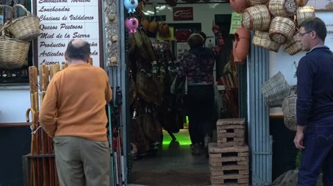 Tourists exploring an Iberian ham and cured meat shop. 库存影片 56476516