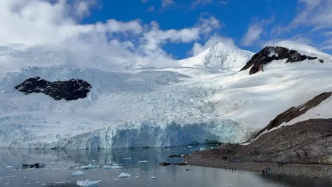 Tourists Exploring Neko Harbour Beneath Towering Antarctic Glacier, Antarctica Stock Footage 337125640