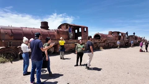 Tourists Exploring the Train Cemetery (Cementerio de Trenes) in Uyuni, Bolivia Stock Footage 334003090