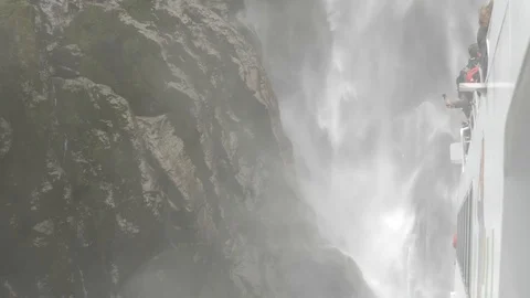 Tourists on a ferry under huge waterfall 스톡 동영상 86004476