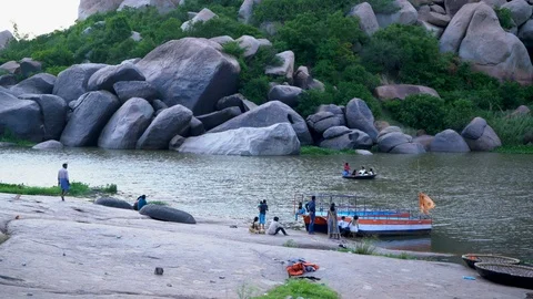 Tourists ferrying across river on round and motor boats. 動画素材 105285805