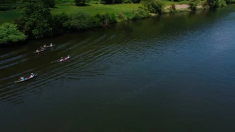 Tourists float on the river kayaking near the green field Stock Footage 155413596