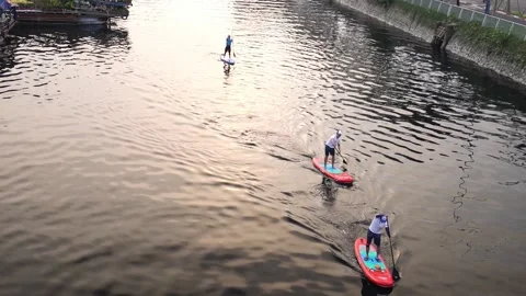 Tourists floating on a SUP boards using paddleboardon along  flower market Stock Footage 141722243