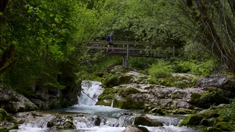 Tourists on Footbridge Over River Rapids at Sunik Water Grove Slovenia Landscape Stock Footage 340878954