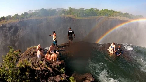 Tourists gather at Devil's Pool, the edge of Victoria Falls, Zambia for a Stock Footage 113200886