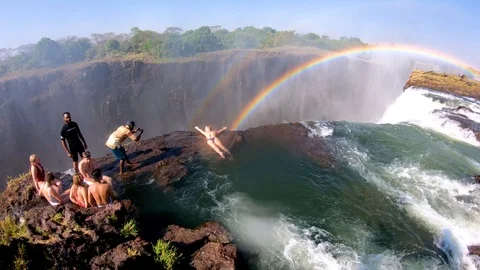 Tourists gather at Devil's Pool, the edge of Victoria Falls, Zambia for a Stock Footage 113200975