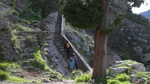 Tourists group climbs up stone steps with parapet to hill Stock Footage 150314000