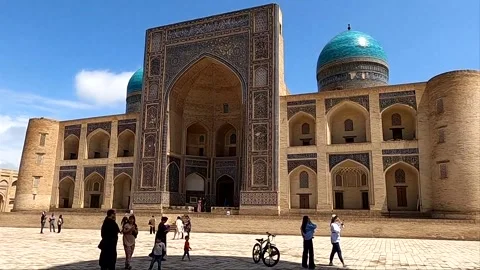 Tourists with a guide at Mir-i Arab Madrassah in ancient Bukhara Vídeos de archivo 335539413