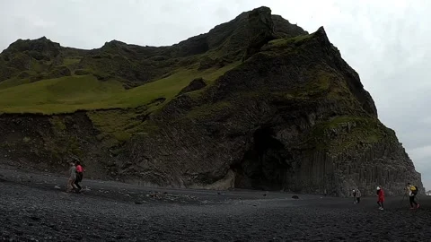 Tourists at Halsanefshellir basalt cave and Reynisdrangar stacks, Iceland Stock Footage 334460231