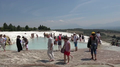 Tourists inside and around a pool on Pamukkale sinter terrace Stock Footage 113222736