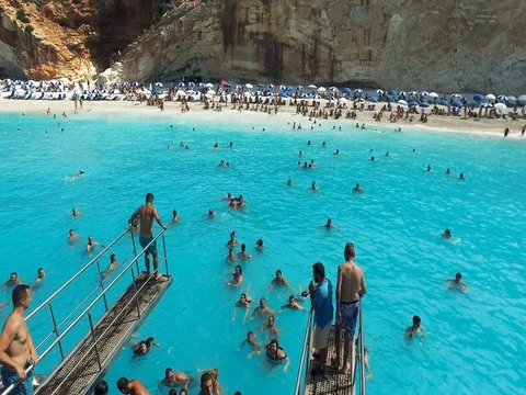 Tourists jumping from a diving board into the turquoise Ionian Sea,Porto Katsiki Stock Footage 80067798