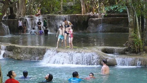 Tourists jumping into waterfall. Stock Footage 75167538