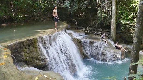 Tourists jumping into waterfall. Stock Footage 75206757