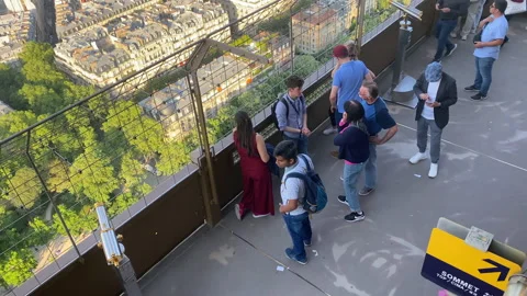 Tourists listening to a tour guide while visiting the Eiffel Tower in Paris Stock Footage 196153906