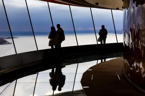 Tourists looking down through big windows to see town of seattle from Space.. Stock Photos