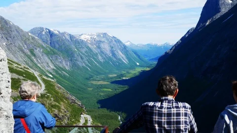 Tourists looking down at Trollstigen or Trolls Path, a popular serpentine road Stock Footage 118157160