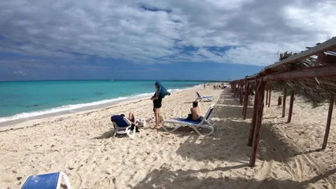 Tourists lying down on benches on a white sand beach of a paradisiac Vídeo Stock 150823044
