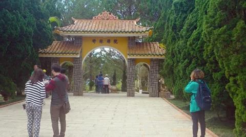Tourists pause for photos beneath the entry arch of a popular public park Stock-Footage 63449975