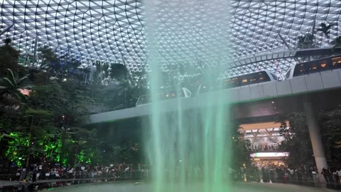 Tourists pause as the train slides by above the glistening waterfall Video stock 318099397