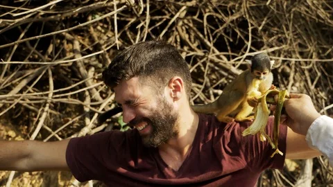 Tourists play with squirrel monkeys during a boat trip at Yacuma river, Bolivia Stockbeeldmateriaal 125486505