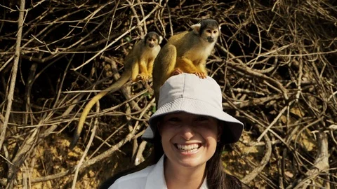 Tourists play with squirrel monkeys during a boat trip at Yacuma river, Bolivia Stockbeeldmateriaal 125486508
