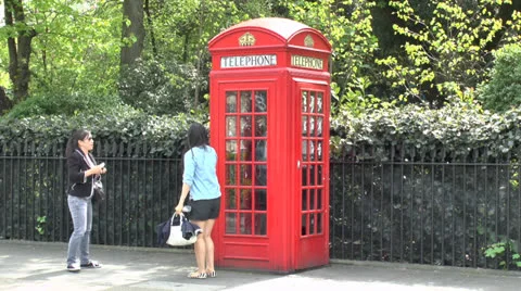 A person posing in front of a red telephone booth photo – Free Model girl  Image on Unsplash