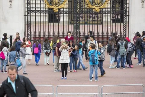 Tourists pose for a self portrait using a cell phone and a selfie stick outsi Stock Photos
