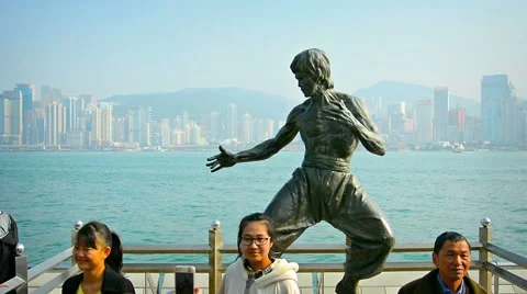 Tourists posing for photos and selfies in front of a bronze statue of Bruce Lee Vidéo 49863473