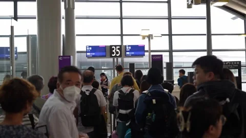 Tourists queing for boarding airplane at checking counter - 4k footage Stock Footage 245553959