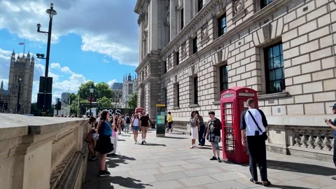 Tourists queue and pose by classic red telephone boxes outside the HM Revenue Stockbeeldmateriaal 345812340