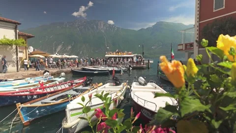 Tourists queue boarding busy crowded ferry Lake Garda harbour pier Stock Footage 313462859