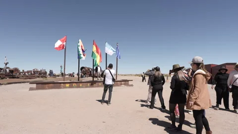 Tourists queue for photos Salar de Uyuni train cemetery Stock Footage 336025359