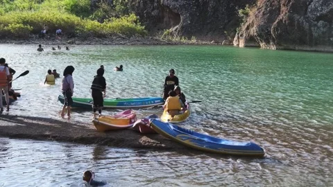 Tourists queue to use canoes to enjoy the natural tourism of the Oya Valley Stock Footage 340298169