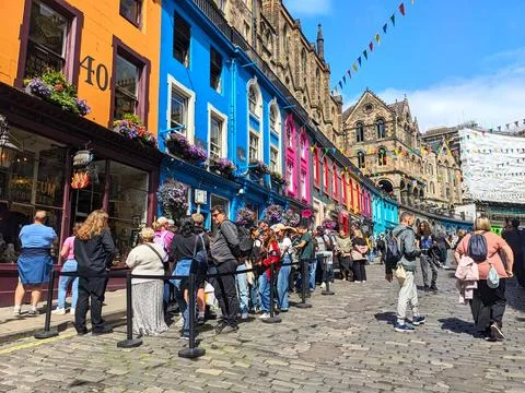 Tourists queuing on the cobblestone path of vibrant Victoria Street in Foto stock