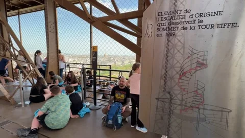Tourists relaxing inside crowded Eiffel Tower with information sign 스톡 동영상 334133937