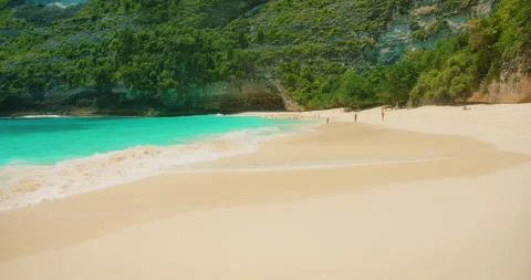Tourists relaxing on tropical pristine sandy beach Kelingking Bali Nusa Penida Stock-Footage 342682331